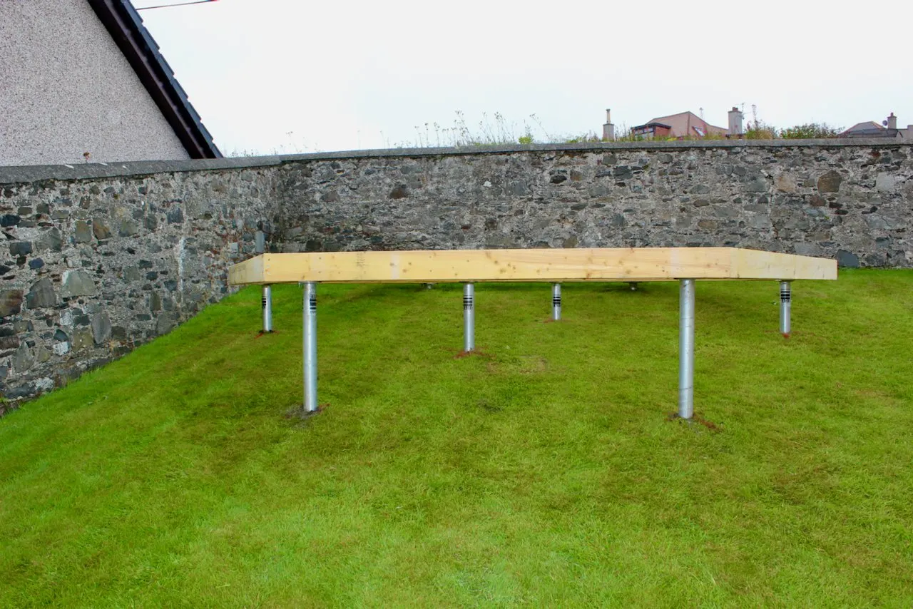 Compact ground screw equipment carried through a house to a rear garden