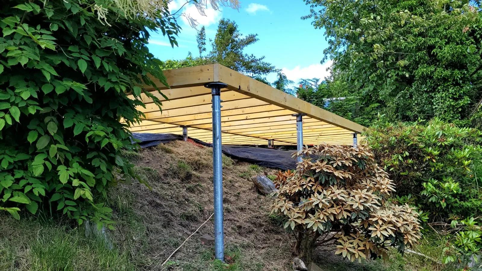 Level deck built on a hillside using ground screws